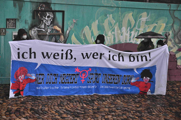 Transpi beim IDAHOBIT in Freiburg. Spruch: &quot;Ich weiß, wer ich bin. Wer dich negiert, spürt unseren Zorn. solidarische trans*inter*non-binary selbstverteidigung