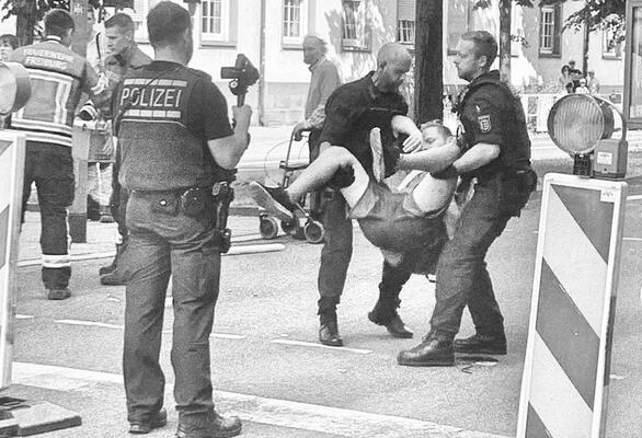 Immerhin noch besser als ein Schmerzgriff: Polizei trägt Aktivist*in bei einer Versammlung der Letzten Generation weg