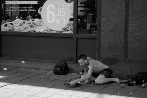 Ein Obdachloser vor einer Pizzeria in Brüssel.