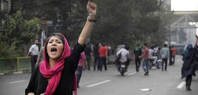 Proteste im Iran - Kopftuchtragende Demontrantin mit erhobener Faust