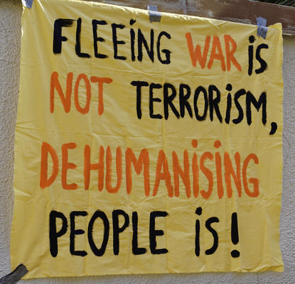 Banner: &quot;Fleeing War is not Terrorism, dehumanising people is!&quot;