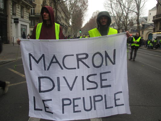 Demonstranten halten ein Transparent mit der Aufschrift &#039;Macron spaltet das Volk&#039; 