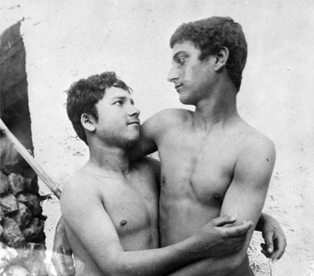 Das Bild zeigt zwei junge, sich umarmende Männer.