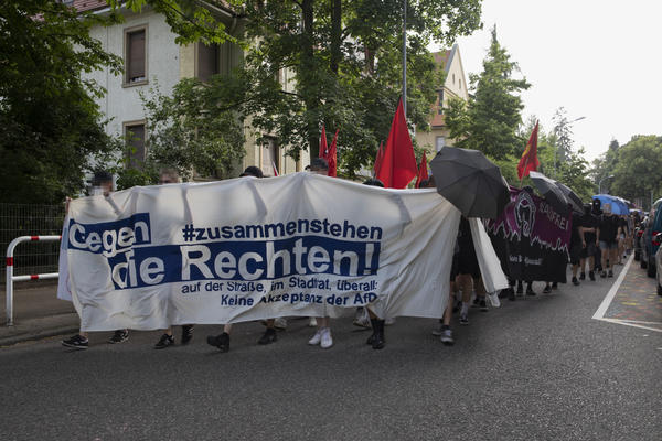 Ein Demoblock mit einem weißen Fronttransparent. Auf dem steht in blauen Buchstaben: &quot;Zusammenstehen gegen die Rechten!&quot;