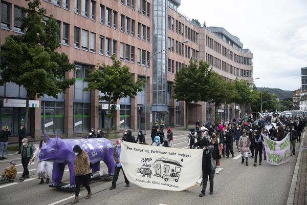 Ein Demonstrationszug mit als Zombies verkleideten bewegt sich in der Basler Str. Vorne weg ein lila Rhino.