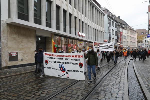 Demonstrationszug mit kurdischen Fahnen zieht die Freiburger Salzstraße entlang. Vorne ein Transparent, auf dem steht: &quot;Einsatz chemischer Waffen. Gestern Saddam - heute Erdogan. Die türkische Regierung gehört auf die Anklagebank&quot;