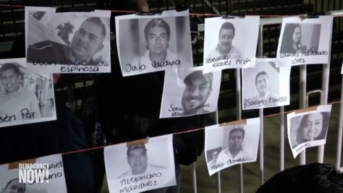 Schwarz-weiß Fotos von ermordeten Journalistinnen und Journalisten hängen mit Namen versehen an einem Zaun