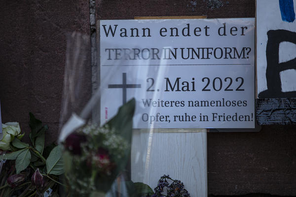 Ein kleines, weißes Schild an dem Ort des Todes am 2.5.22: Wann endet der Terror in Uniform? 2. Mai 2022, Weiteres namenloses Opfer, ruhe in Frieden!