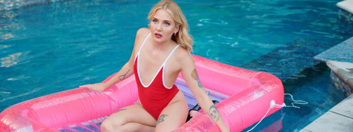 Hauptdarstellerin Sofia Kappel als Linnéa im roten Badeanzug auf pinker Luftmatratze im Pool