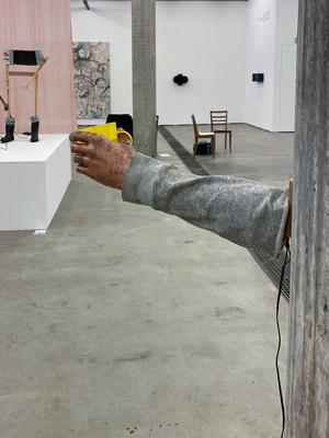 Arm an einer Wand montiert mit gelber Kaffeetasse