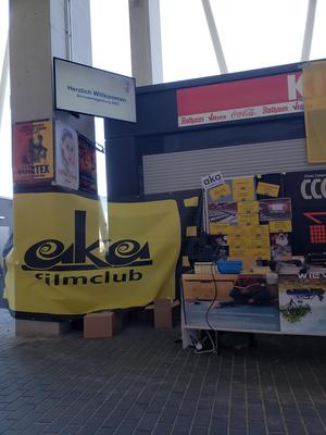 der Stand des  aka filmclub beim Markt der Möglichkeiten im Neuen Stadion: geschmückt mit einem schwarz-gelben Banner, Filmplakaten, Projektor, DVDs und Programmheften