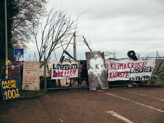 Barrikade im besetzen Dorf Lützerath mit verschiedenen Bannern für den Erhalt von Lützerath 