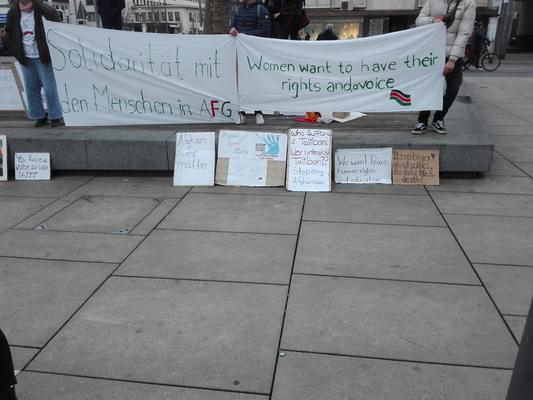 Zwei Banner auf denen &quot;Solidarität mit den Menschen in AFG&quot; und &quot;Women want to have their rights and voice&quot;