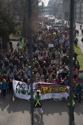 Der Demonstrationszug des Klimastreiks von oben, zwischen Brückengeländer fotografiert. Auf dem Fronttransparent steht: &quot;Act now!&quot; und &quot;ÖPNV statt Stau&quot;.