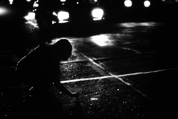 schwarzweisse Fotogarfie einer Person auf einer Straße