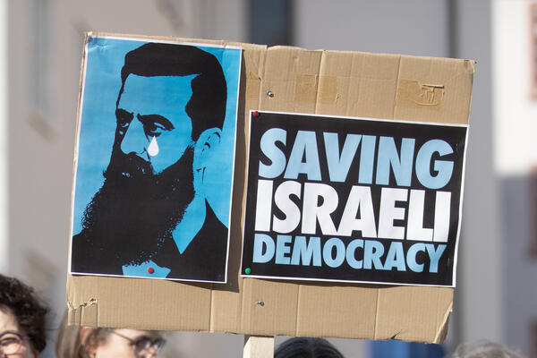 Ein Pappschild, auf dem ein weinender Theodor Herzl abgebildet ist und daneben der Slogan &quot;Saving Israeli Democracy&quot;.