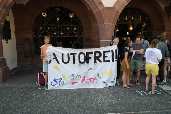 Protest für autofreie Rempartstraße mit Transparent AUTOFREI vor dem Freiburger Rathaus