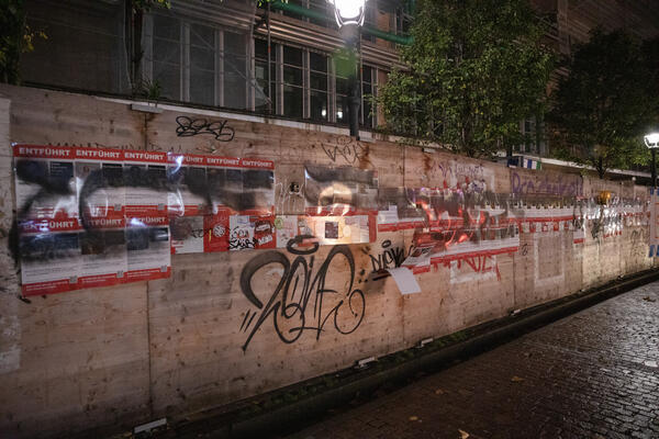 Im Dunkeln ist die Bauwand vor dem KG2 der Uni Freiburg in der Bertoldstraße die rot umrandeten Plakate mit &quot;Vermisst&quot; zu erkennen, die mit schwarzer Lackfarbe besprüht wurden.