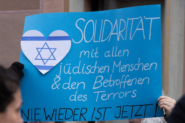 Ein blaues Plakat mit einem weißen Herz mit Davidstern und zwei blauen Streifen: Solidarität mit allen jüdischen Menschen &amp; den Betroffenen des Terrors - Nie wieder ist jetzt!