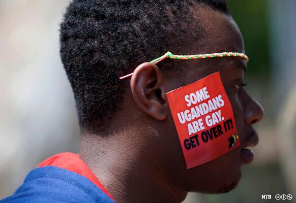 Person mit einem Schild some ugandans are gay -get about it