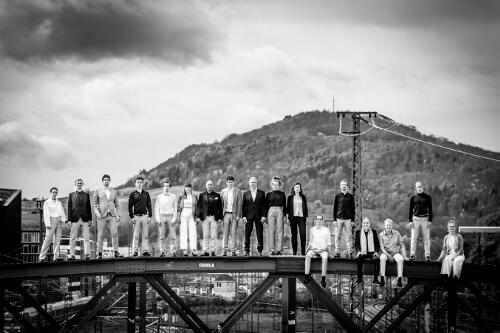 Die Sänger_innen des Jazzchor Freiburg stehen auf der Blauen Brücke in Freiburg