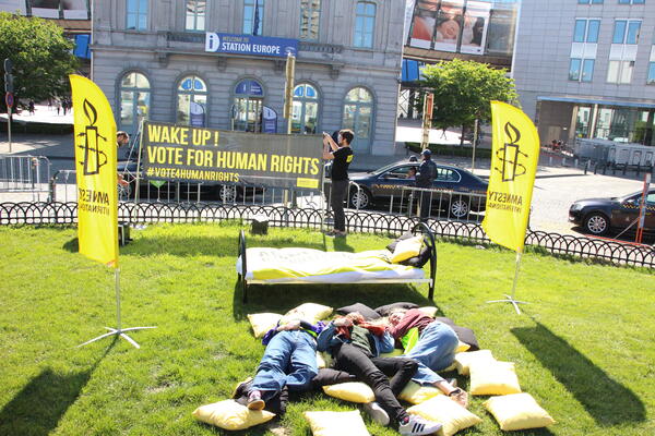 Amnesty Aktivisten liegen auf der Wiese bei einer Europaveranstaltung