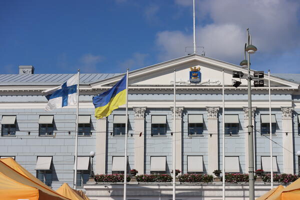 Rathaus von Helsinki mit finnischer und ukrainischer Fahne davor.