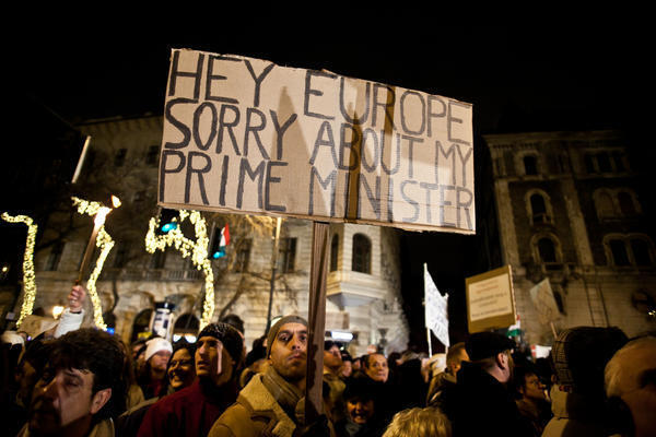 Menschen protestieren mit einem Schild: Hey Europa, sorry about my prime minister.&quot;