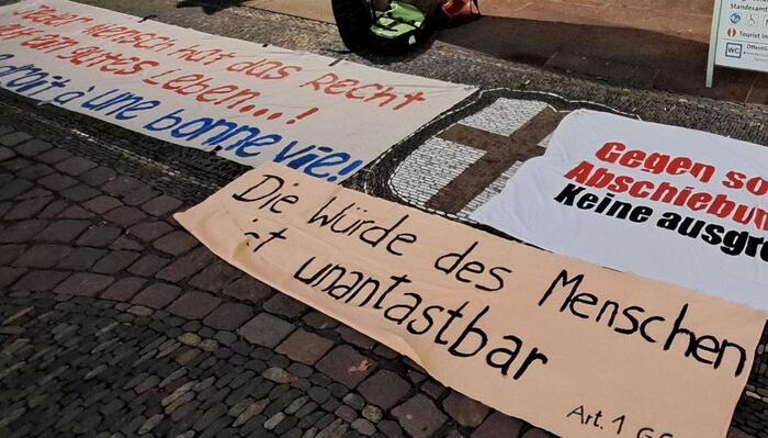 Banner auf dem Boden mit der Aufschrift: &quot;Die Würde des Menschen ist unantastbar, Art. 1 GG&quot; 