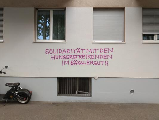 &quot;Solidarität mir den Hungerstreikenden im Bässlergut!!&quot; - Graffiti an einem Wohnhaus in der Baseler Innenstadt.