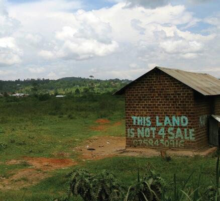 Haus in Uganda mit der Aufschrift Land is not for sale