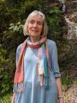 Foto von Rosmarie Wydler Wälti - eine jugendlich wirkende weißhaarige Frau mit buntem Schal.