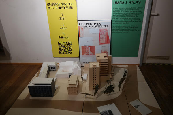 Foto aus der Ausstellung: Fix it – Umbau statt Abriss im Karlsbau. Dargestellt ist das Europaviertel - im Hintergrund findet sich ein Hinweis auf den Umbau-Atlas