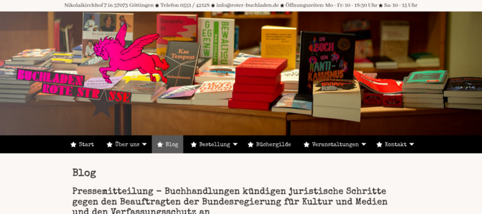 Bild von Seite des Roten Buchladens in Göttingen, u.a. mit Büchertisch und PM zum Vorgehen gegen Aberkennung des Buchhandlungspreises