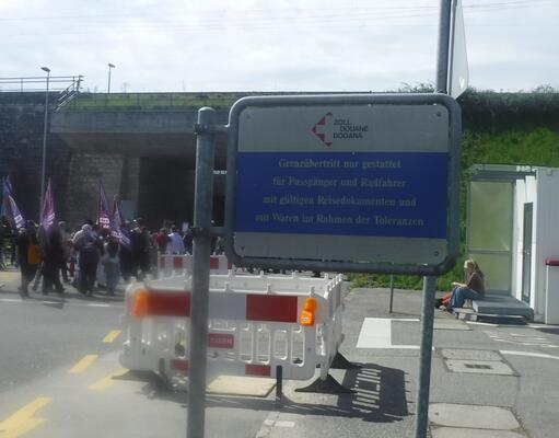 links der demo zug rechts ein schild mit der aufschrift dass der grenzübertritt nur für radfahrer und fussgänger gestattet ist