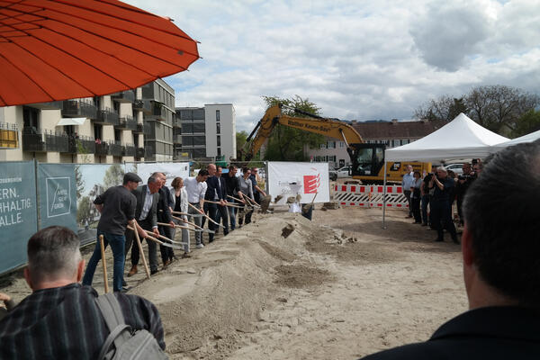 Spatenstich im Metzgergrün. Links im Bild die neuen Häuser; am Horizont hinter dem Bagger, die Reste des alten Metzgergrüns