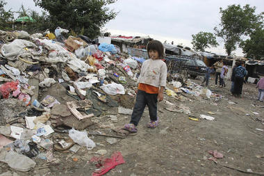 Kleinkind vor Müllberg neben informeller Siedlung 2013 in Serbien - Aber Roma-MigrantInnen treffen auch in Frankreich auf Diskriminierung und schlechte Lebensbedingungen