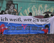 Transpi beim IDAHOBIT in Freiburg. Spruch: "Ich weiß, wer ich bin. Wer dich negiert, spürt unseren Zorn. solidarische trans*inter*non-binary selbstverteidigung