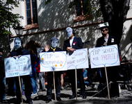 Attac-Mitglieder demonstrieren als Finanzhai, Merkel, Gabriel und Juncker verkleidet gegen TTIP.