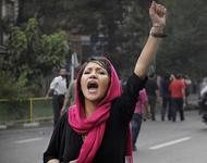 Proteste im Iran - Kopftuchtragende Demontrantin mit erhobener Faust