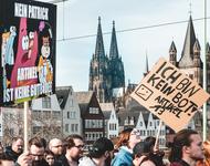 Menschen demonstrieren vor dem Hintergrund des Kölner Doms gegen Artikel 13 der EU-Urheberrechtsreform