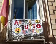 Banner mit der Aufschrift "Andra tutto bene" an einem Balkon in Italine.