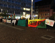 Reihe von Demontrant*innen, die Transparente halten, auf denen unter anderem "Defend Afrin" und "Fight for Rojava" steht.