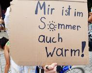 Ein Pappschild auf dem steht: "Mir ist im Sommer auch warm!" Das "o" ist als sonne gemalt.