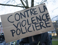 Ein Pappschild, auf dem "Contre La Violence Policiere" steht.