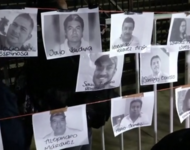 Schwarz-weiß Fotos von ermordeten Journalistinnen und Journalisten hängen mit Namen versehen an einem Zaun