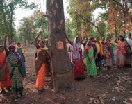 Adivasi Frauen singen und protestiere in bunten Kleidern