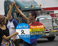 Zwei Frauen halten sich während eines Gay Pride Marches in Nicaragua an den Händen. Zusammen halten sie ein Plakat in Regenbogenfahnen, in dem Freiheit, Respekt und Rechte für LSBTI gefordert wird.