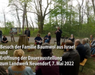Besuch der Familie Baumwol aus Israel - eine Gruppe Menschen sitzt im Wald um die mit Blumen geschmückte Statue der ermordeten Jutta Baumwol