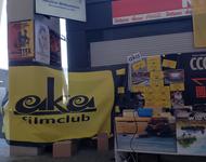 der Stand des  aka filmclub beim Markt der Möglichkeiten im Neuen Stadion: geschmückt mit einem schwarz-gelben Banner, Filmplakaten, Projektor, DVDs und Programmheften